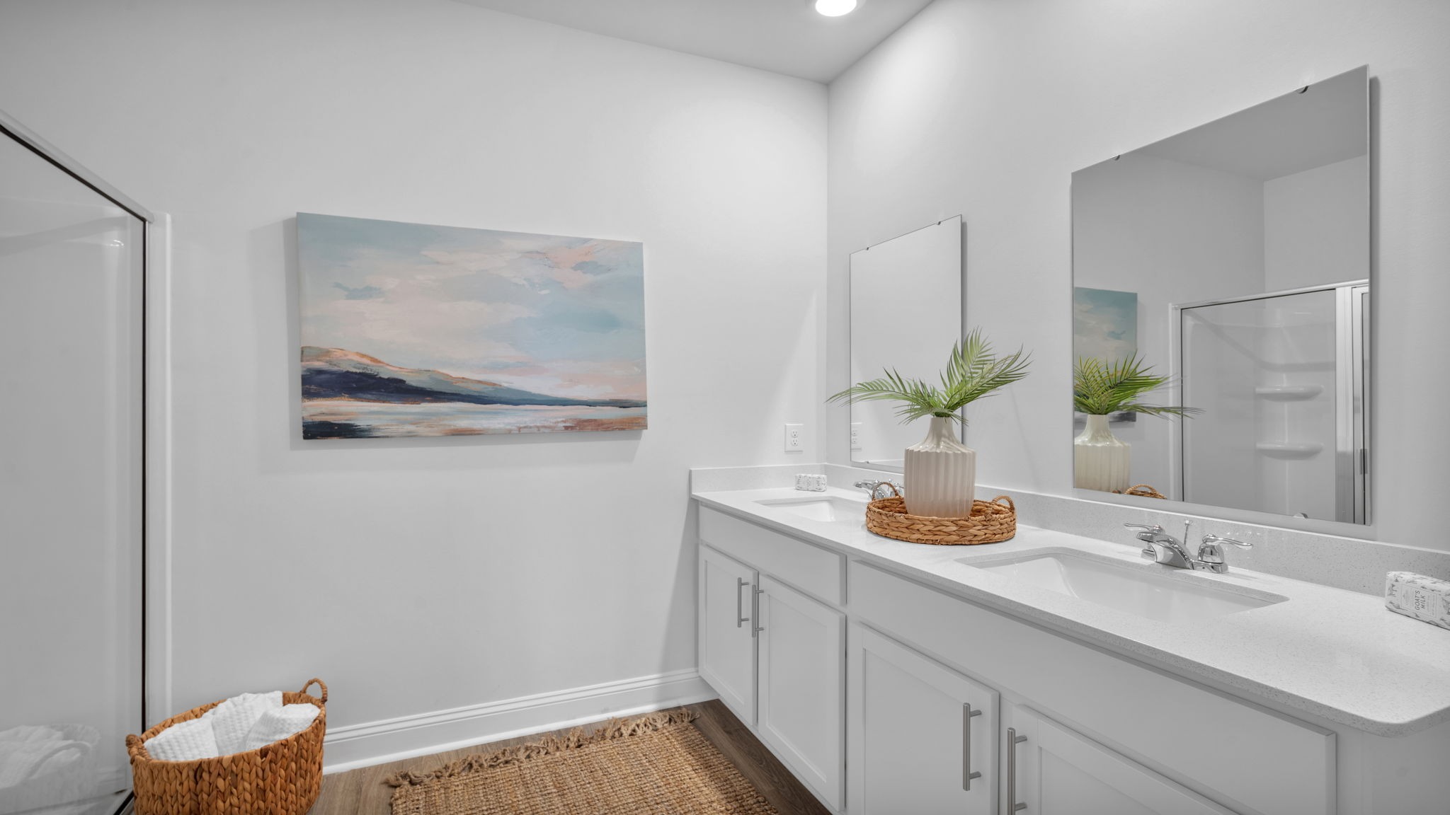 Primary bathroom with double vanities and a stand-up shower