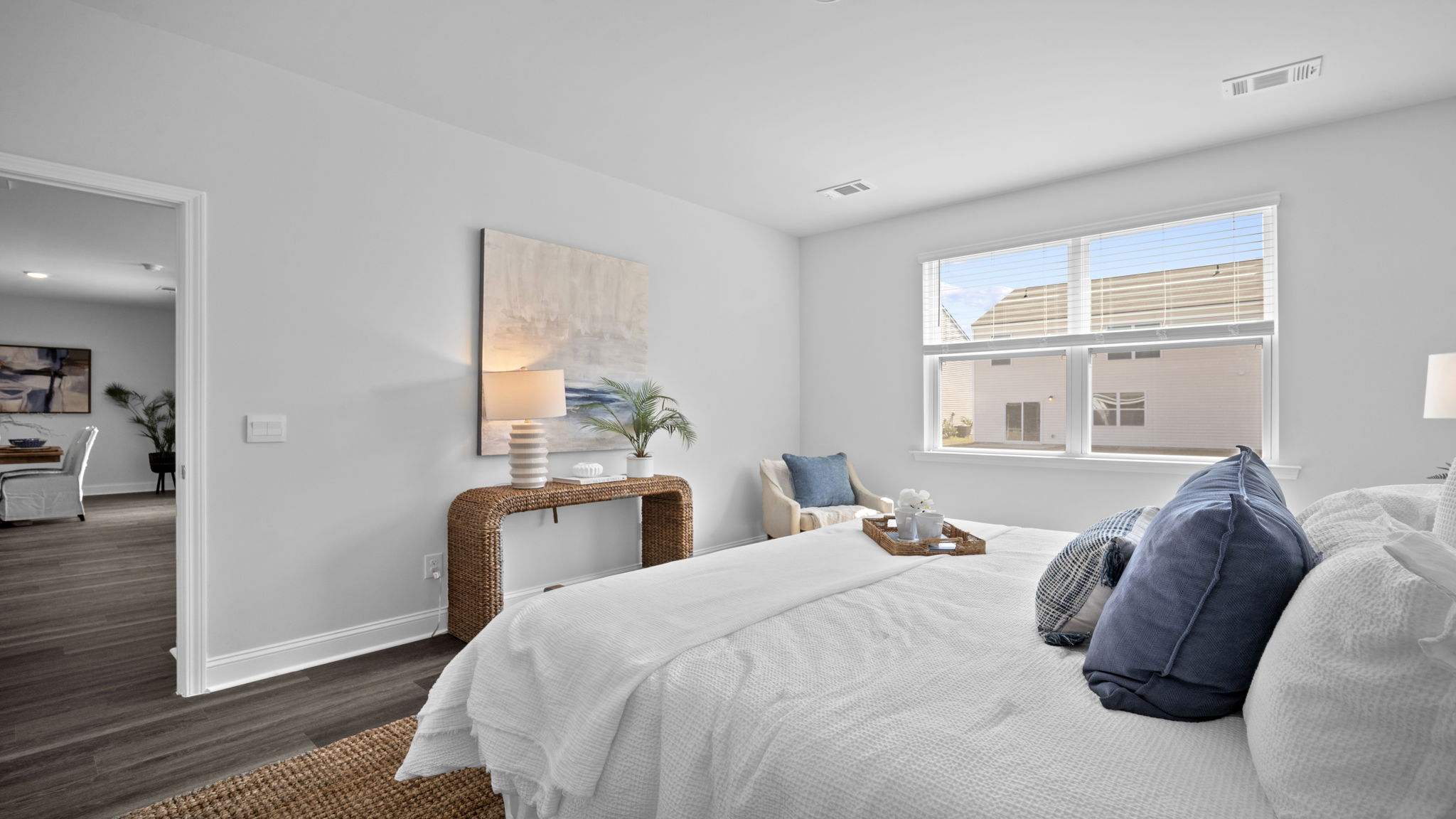 Primary bedroom decorated with a bed, side table, bench and a chair