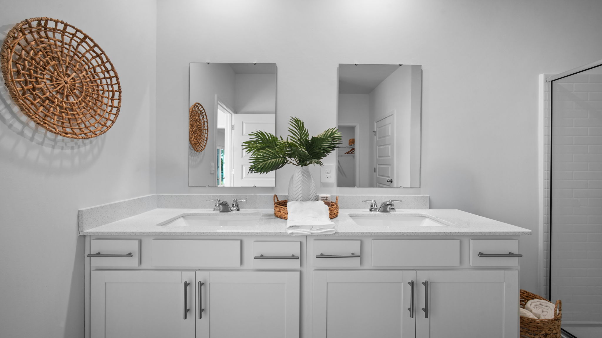 Spacious owner's bath in the Cali home featuring double vanities, ample storage, and a large walk-in shower.