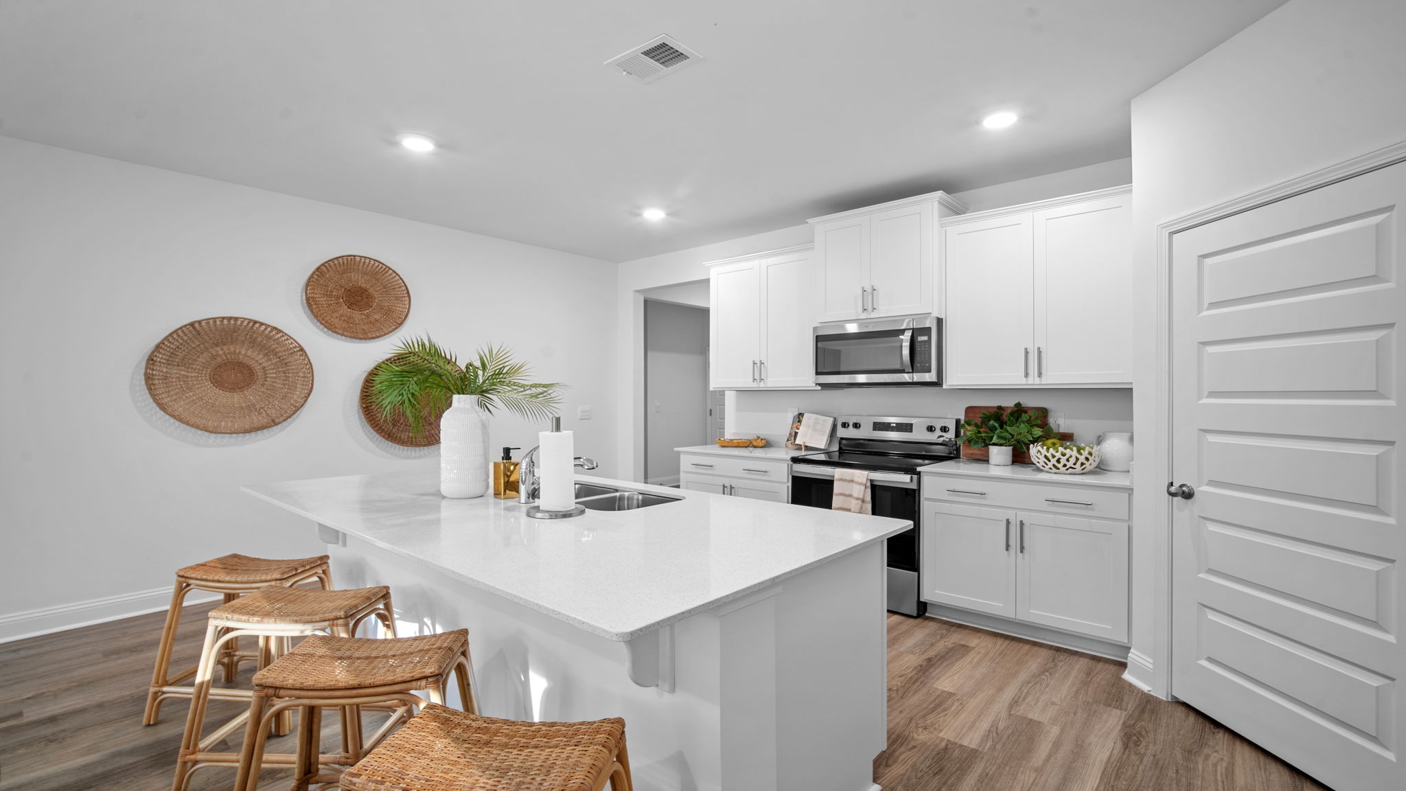 Modern kitchen in the Cali floor plan at Rice Hope featuring an oversized center island, stainless steel appliances, walk-in pantry, and open-concept layout perfect for entertaining.