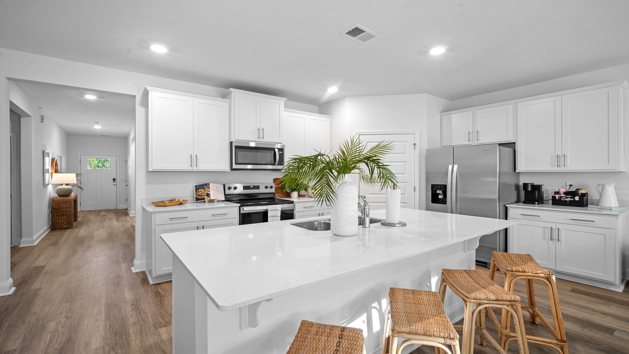 Spacious kitchen in D.R. Horton’s Cali home at Rice Hope with abundant cabinetry, large island seating, and seamless flow into the dining and living areas.