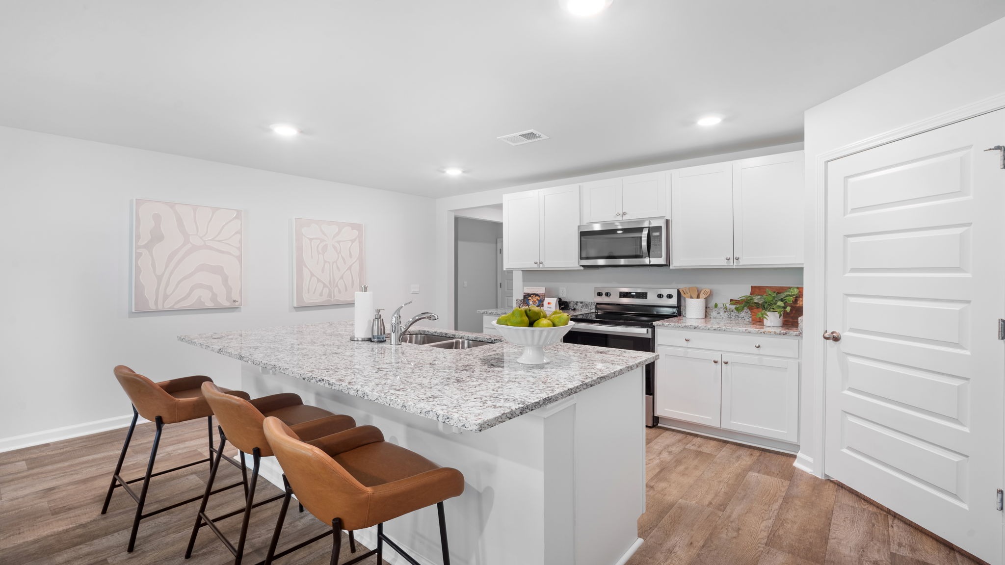 Bright open kitchen in the Rice Hope Cali floorplan featuring modern finishes, functional workspace, and direct views into the dining and living areas.