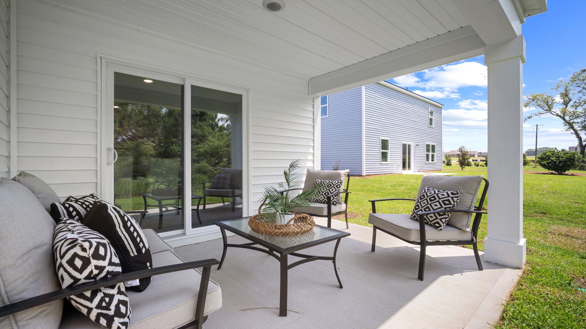 Covered back patio in the Cali home offering a comfortable outdoor retreat for entertaining guests and enjoying the community's resort-style atmosphere.