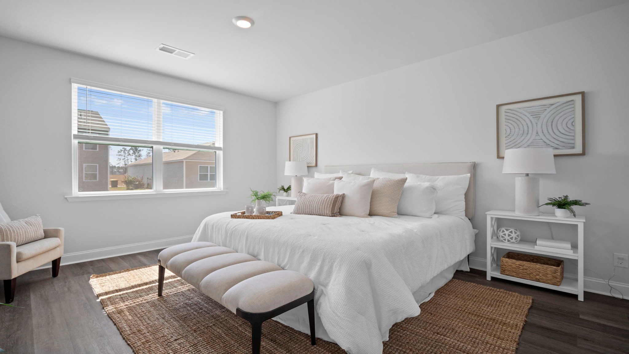 Primary bedroom decorated with a bed, bench, side table and seating