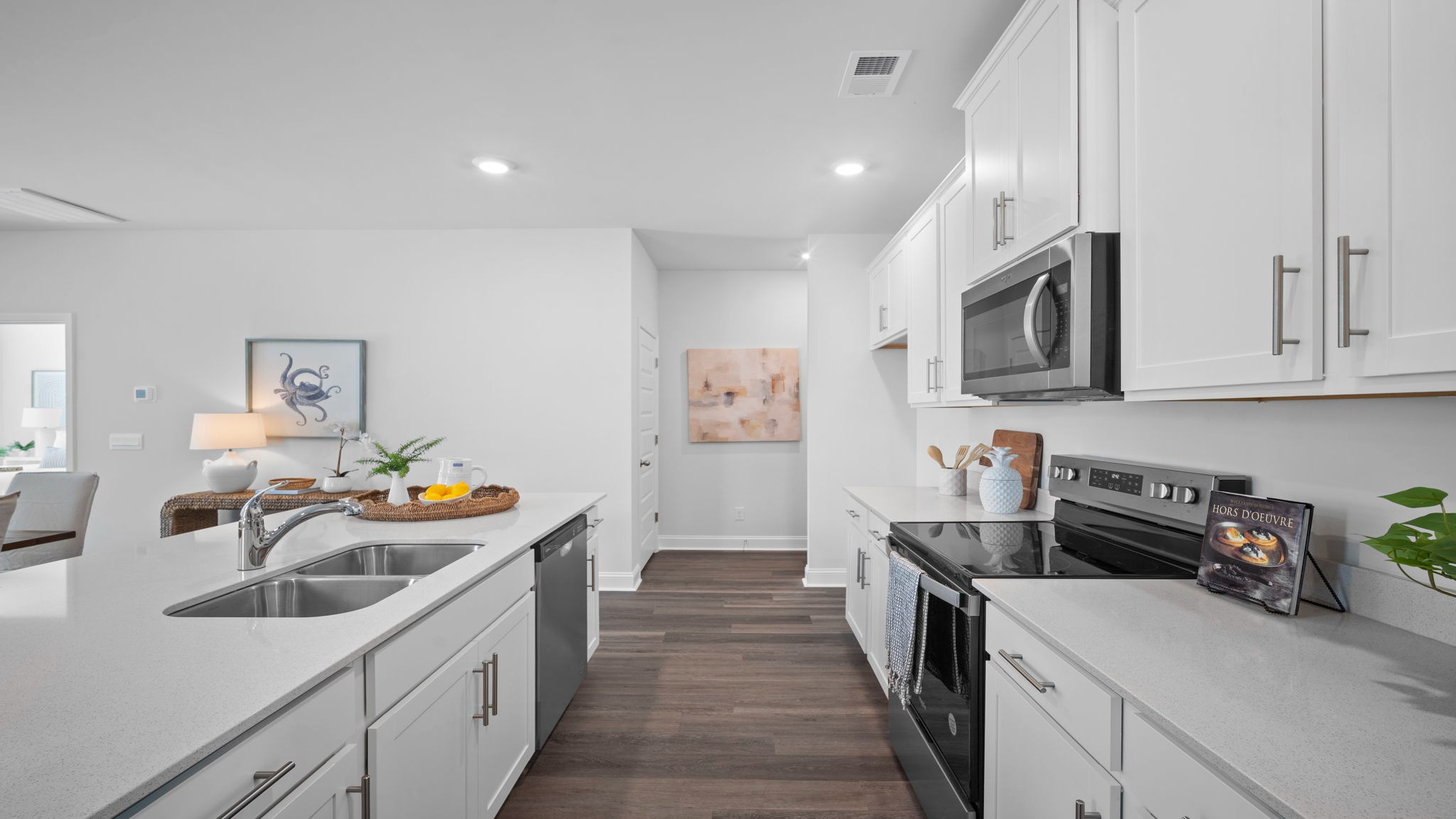 Kitchen walkway with counters on both sides and a stainless dishwasher in the island