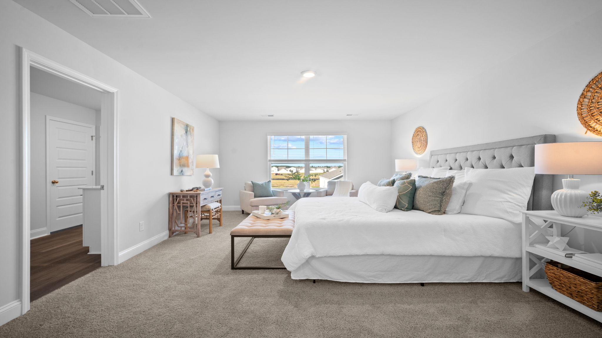 Primary bedroom decorated with a bed, dresser and a side table