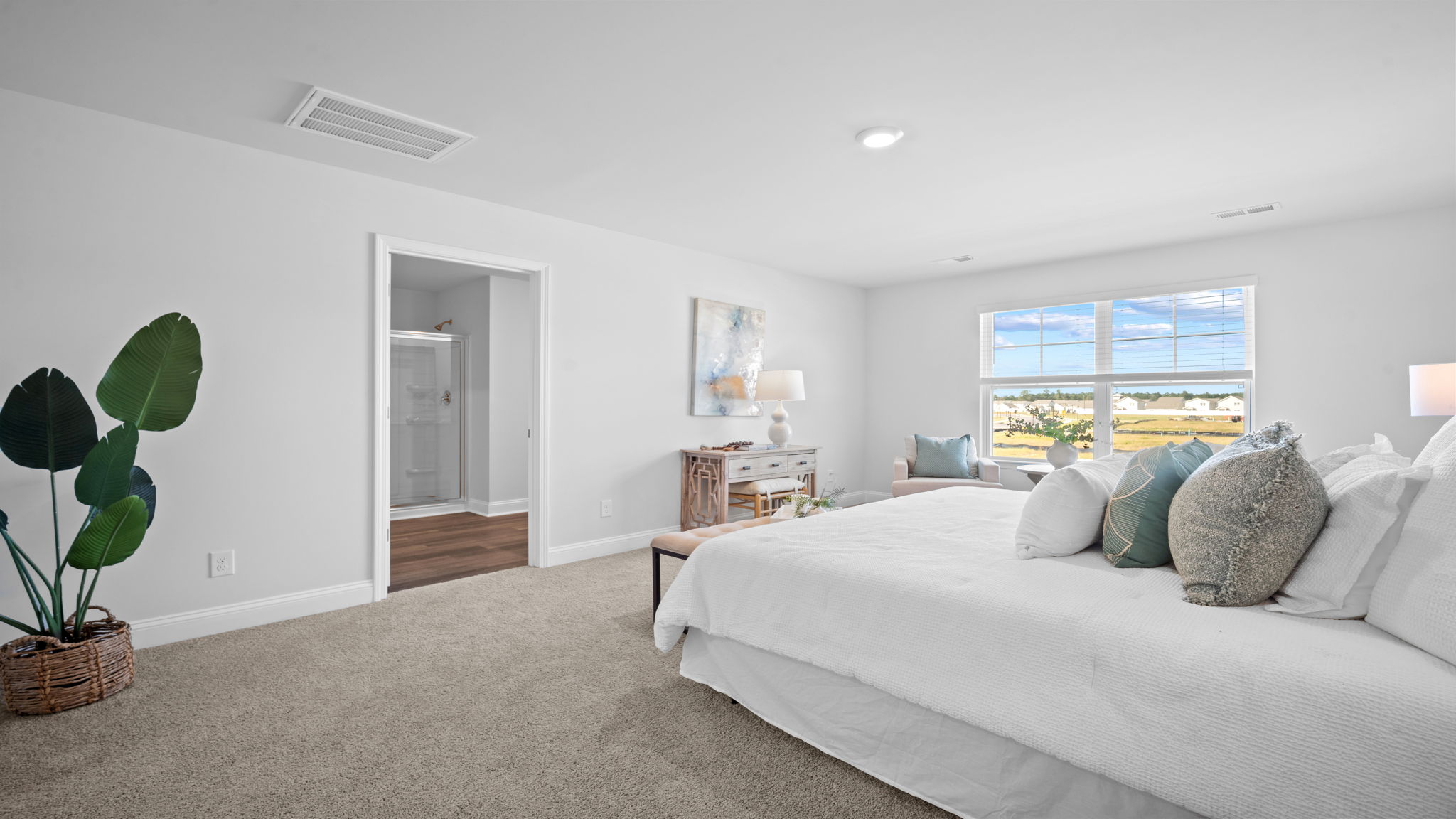 Primary bedroom with hardwood floors, large windows, and trey ceilings.