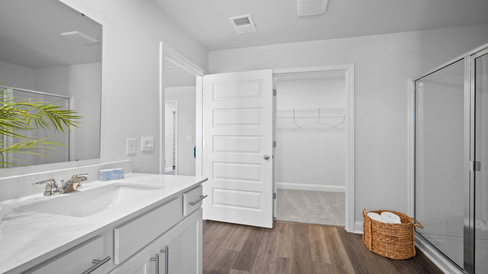 Primary bathroom with tile walk in shower, bright light fixtures, and with built in shelves.