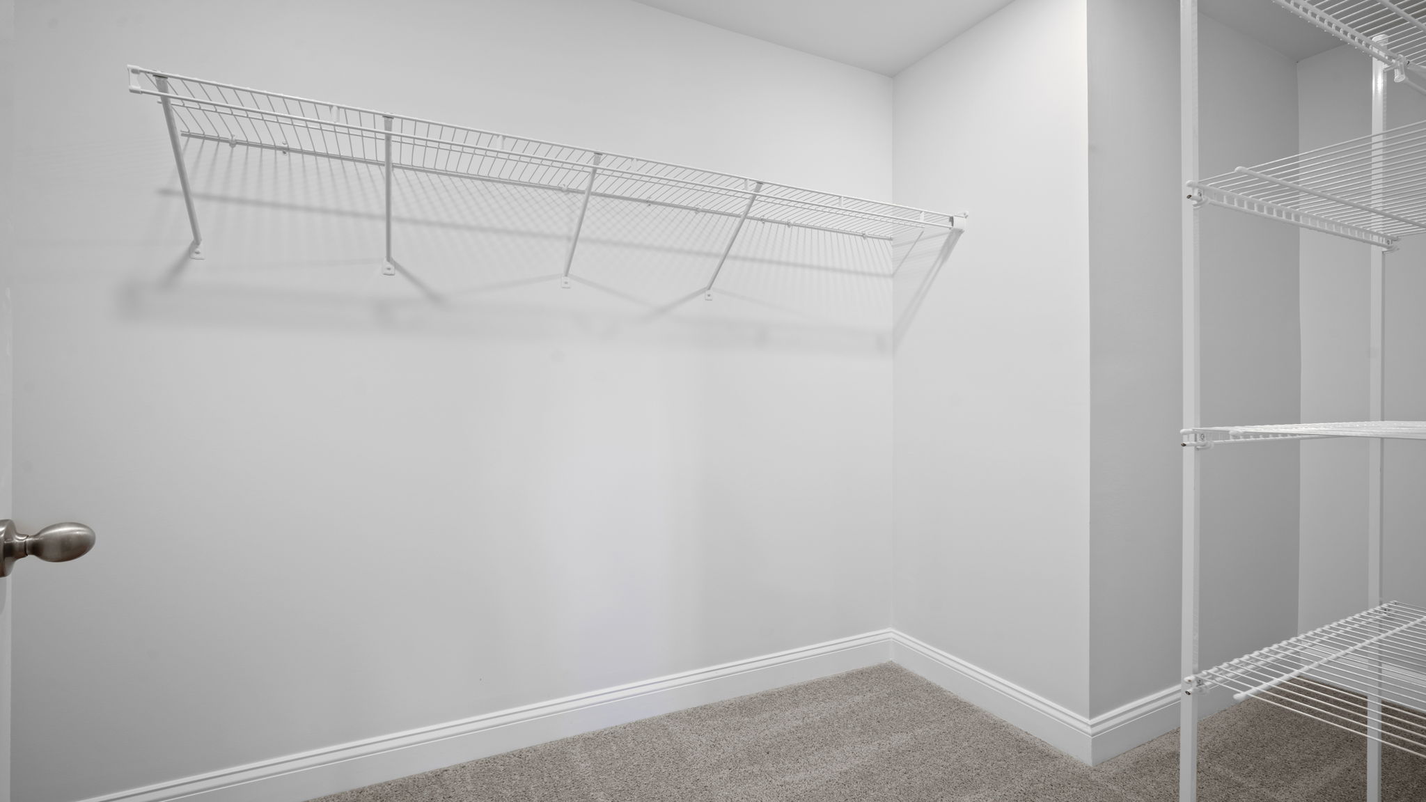 Spacious walk in closet with built in shelving in the primary bathroom.