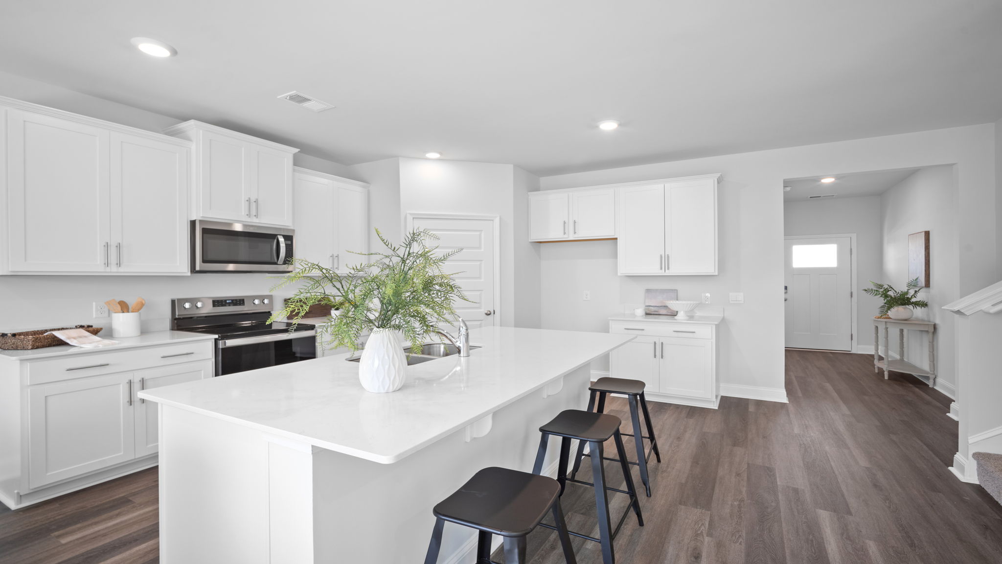Large kitchen area with view with foyer behind.