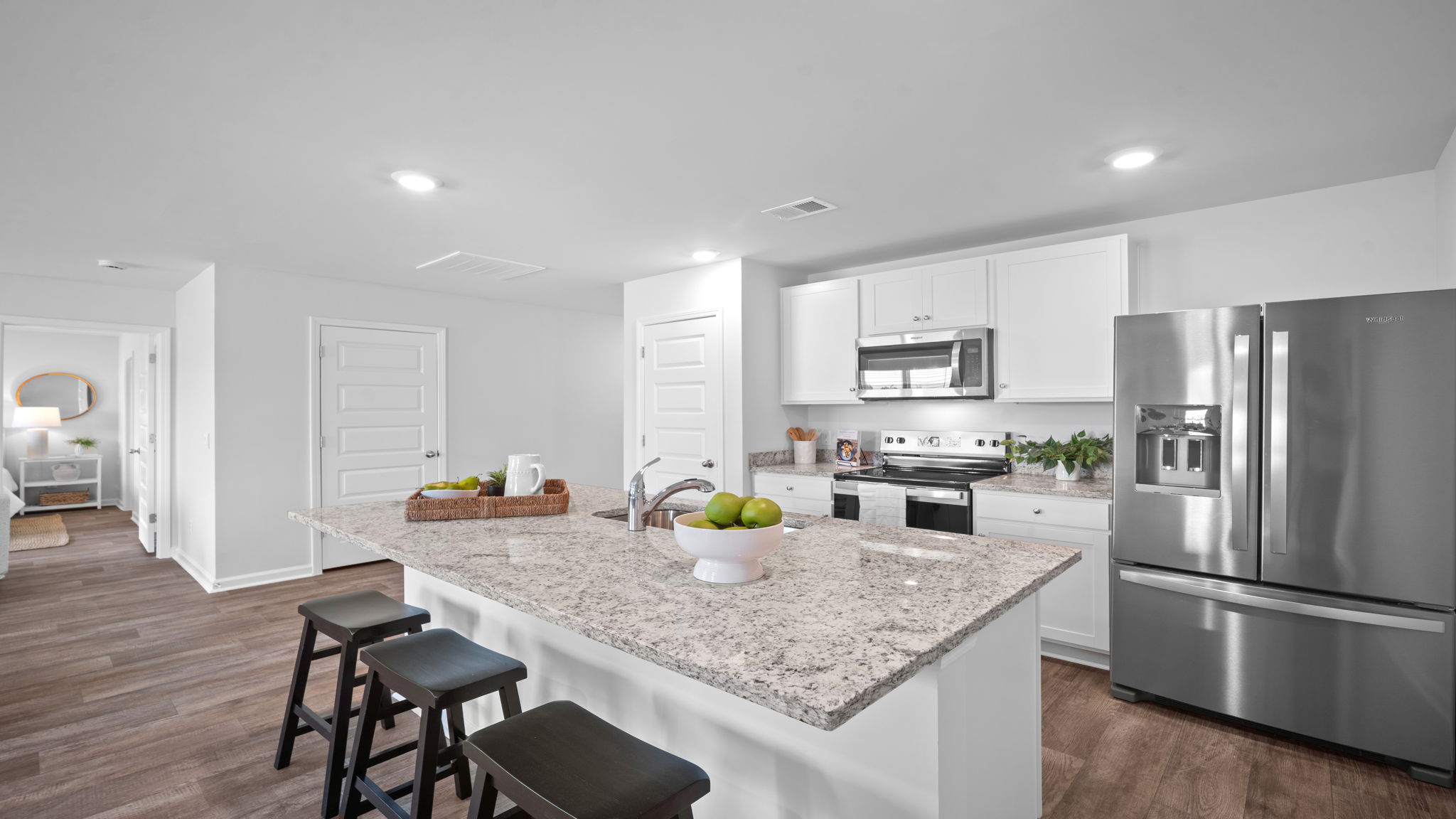 Kitchen area with granite countertops, large island, cabinets, tile backsplash, and stainless steel appliances