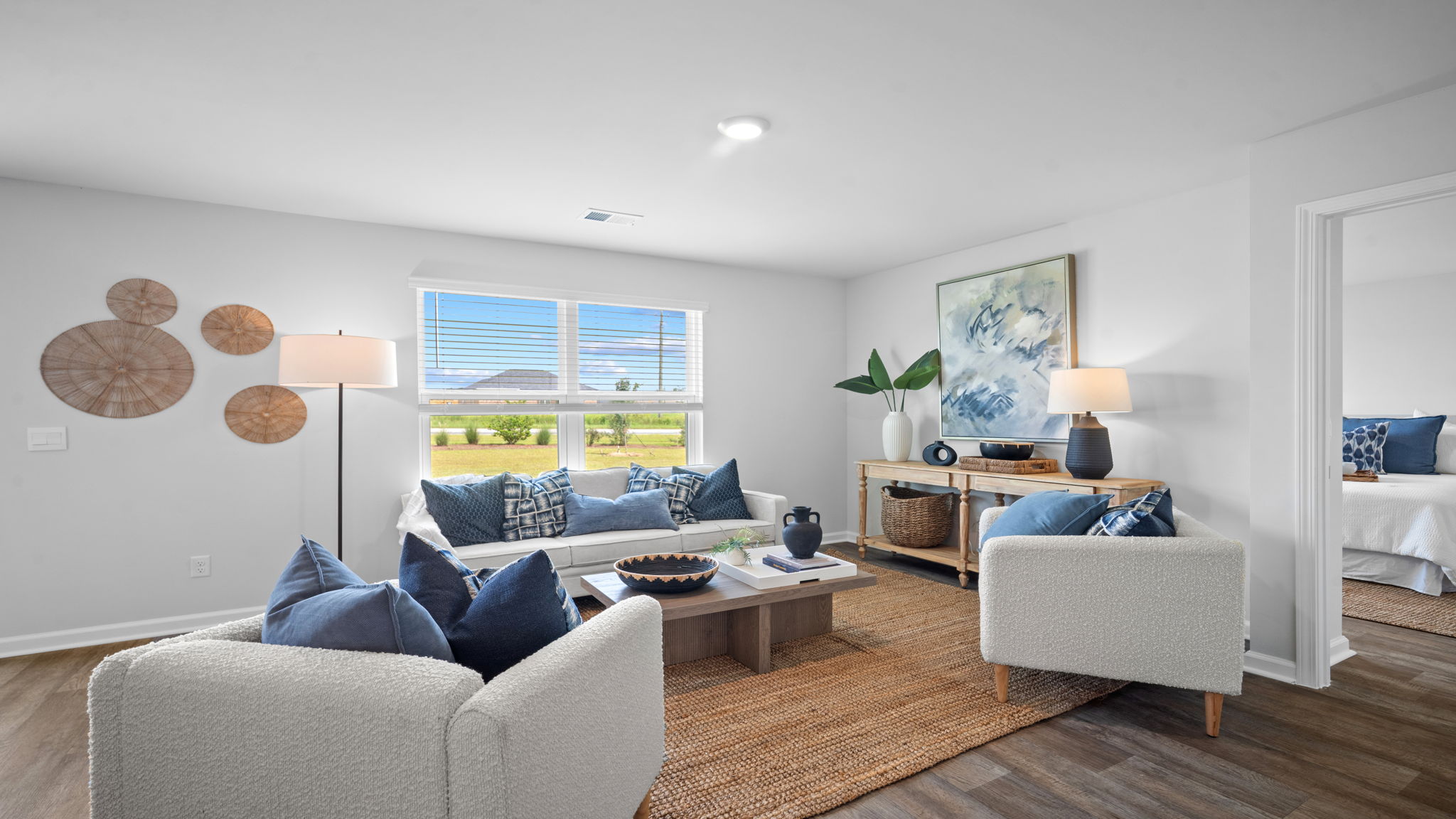 A spacious open floor plan living room and kitchen area with hardwood floors, and trey ceilings.