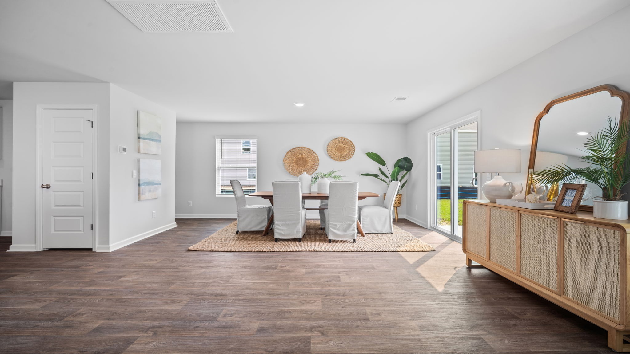 A spacious open floor plan living room and kitchen area with hardwood floors, and trey ceilings.