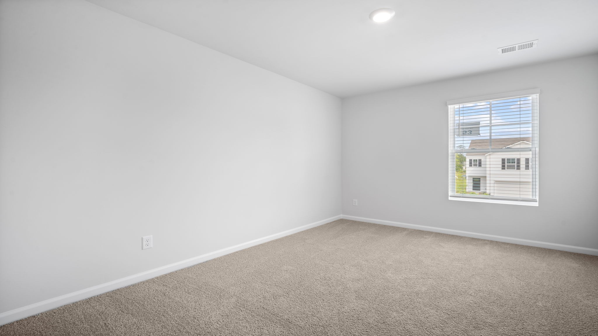 Bedroom with carpeted floors and large single window for natural light.