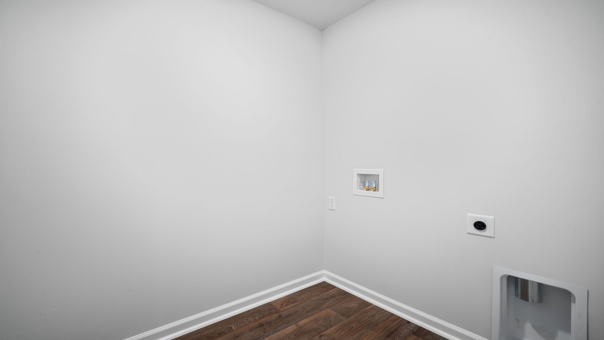 Spacious laundry area has room for a washer and dryer with built in shelves.