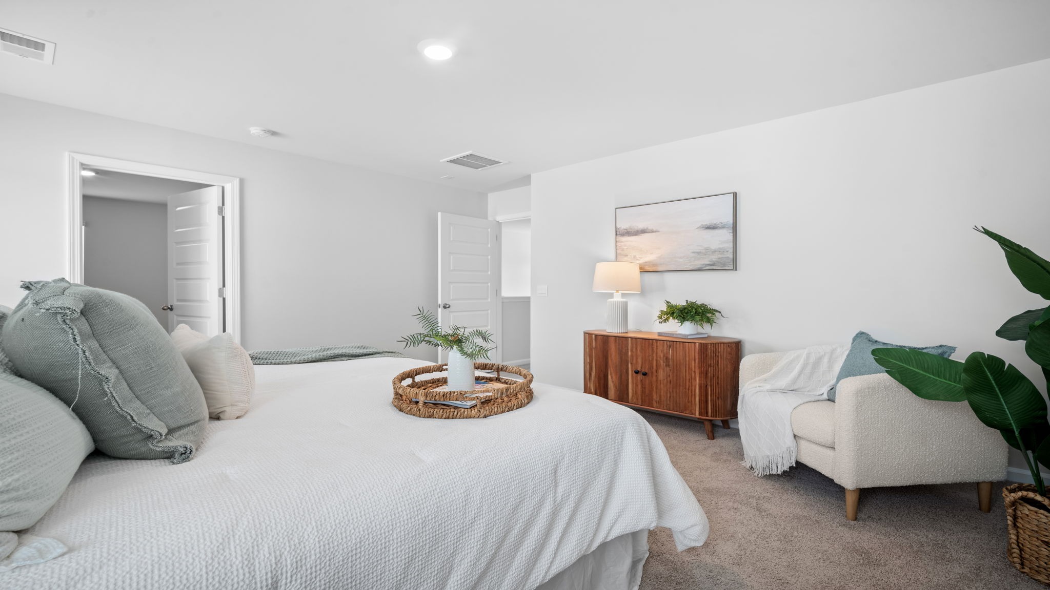 Primary bedroom and door connecting the primary bathroom and entry door.