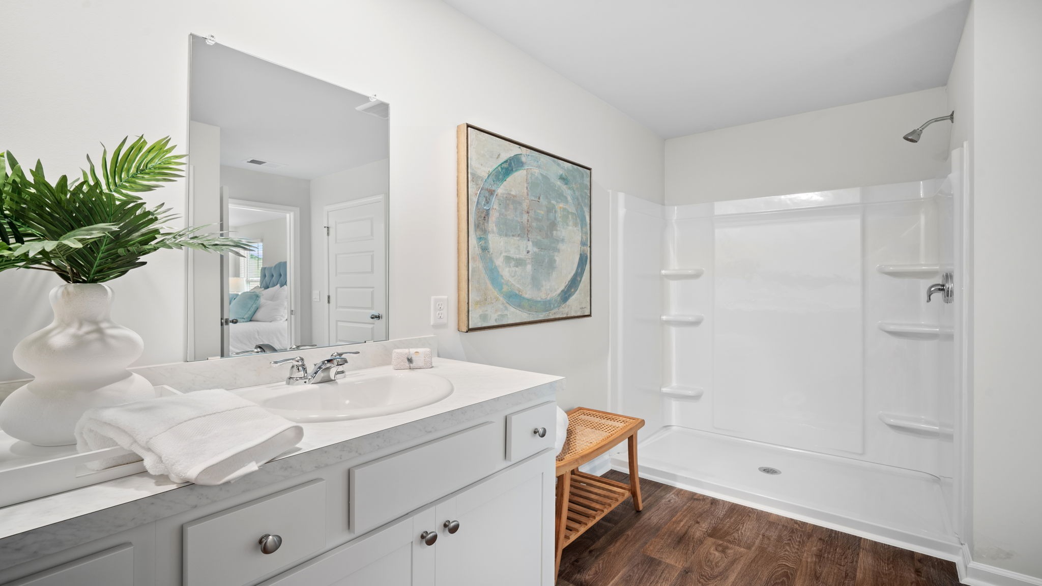 Primary bathroom with tile walk in shower, bright light fixtures, and with built in shelves.