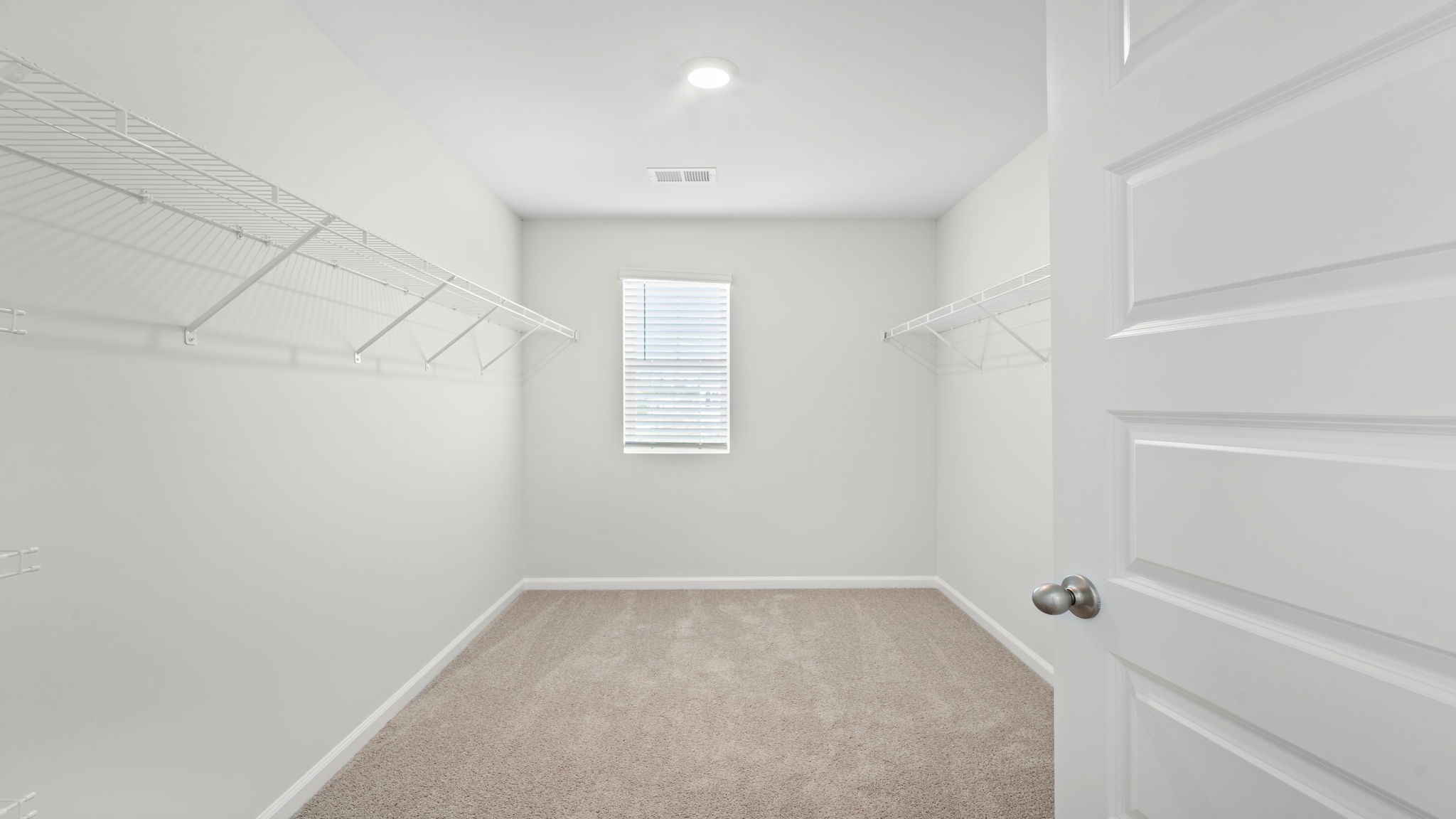 Spacious laundry area has room for a washer and dryer with built in shelves.