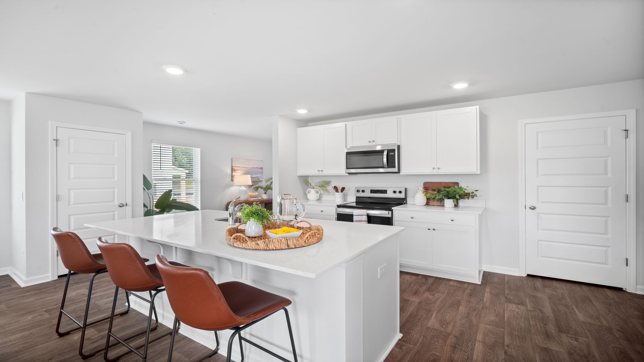 Kitchen island with bar seating and an oven range on the opposite wall