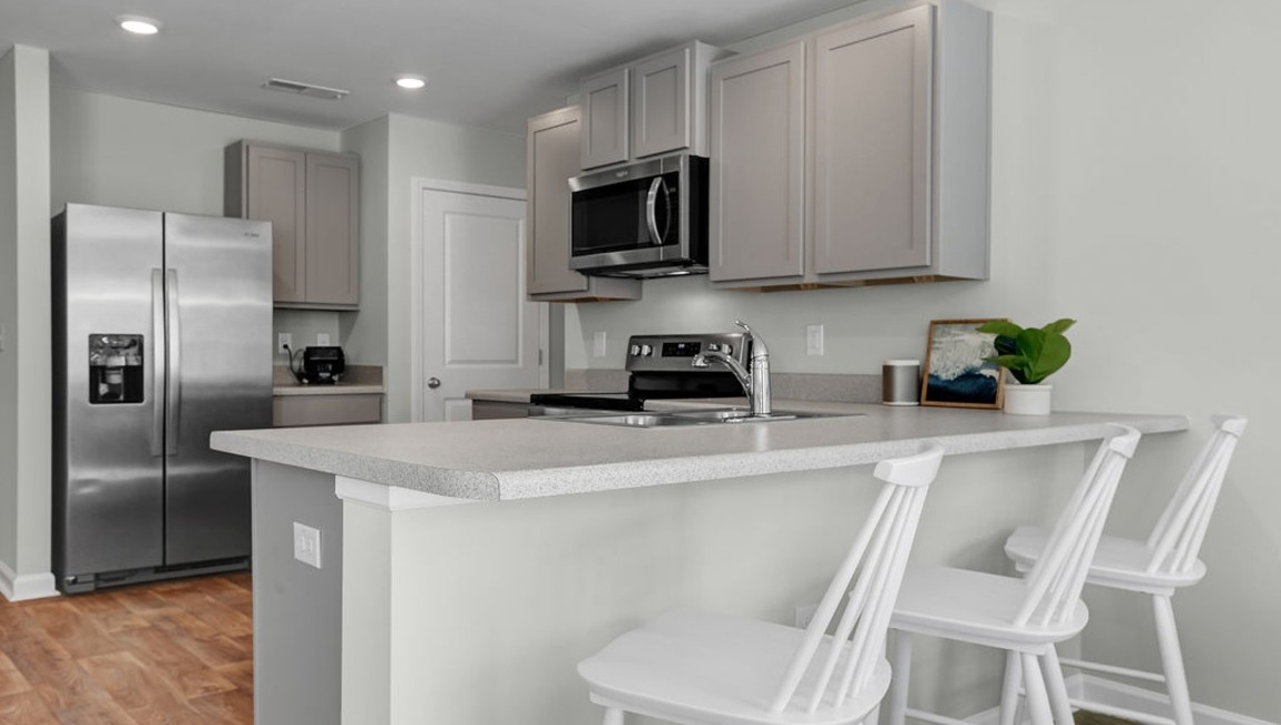 Open-concept kitchen in the Macon home showcasing designer finishes, abundant storage, and seamless flow into the dining and living areas.