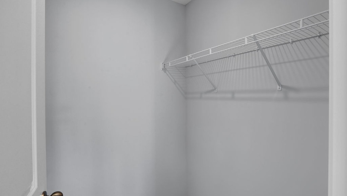 "Large walk-in closet in the Macon floor plan by D.R. Horton featuring ample storage space and convenient access from the primary suite."