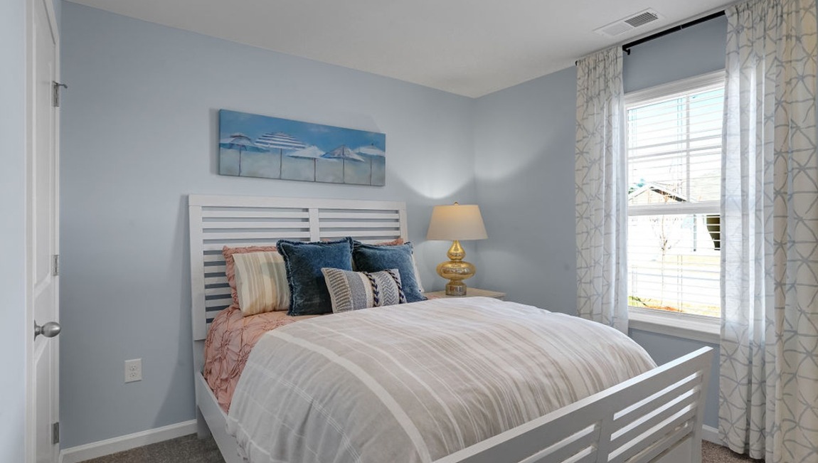 "Comfortable secondary bedroom in the Macon floor plan featuring natural light, ample closet space, and versatile functionality."