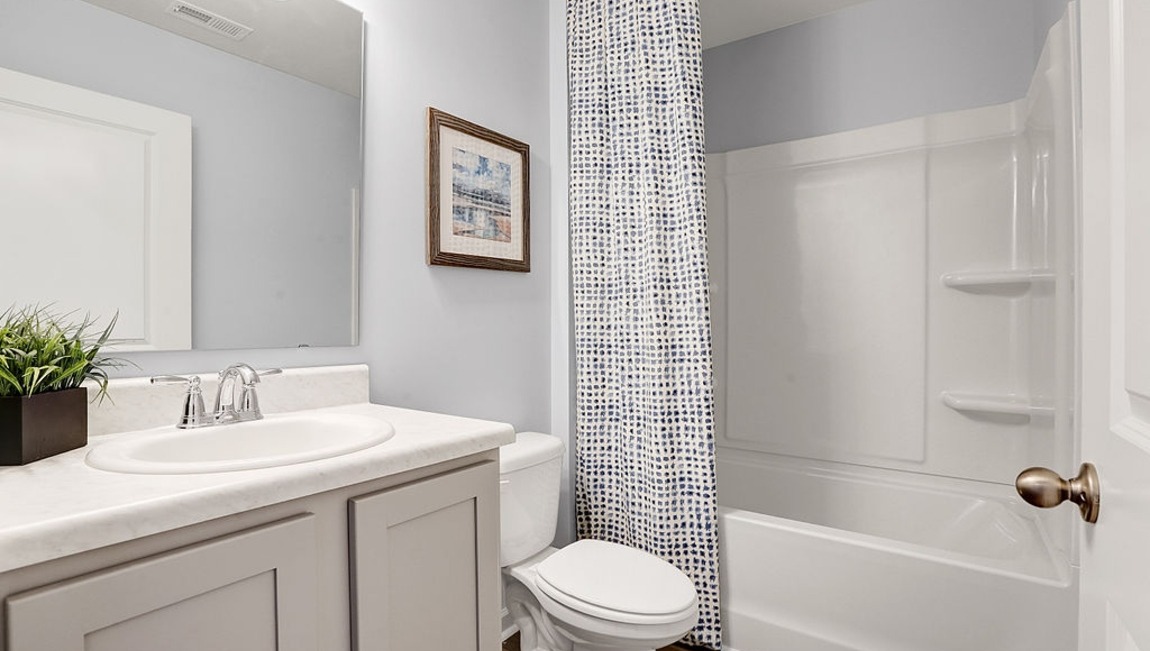 "Modern guest bathroom in the Macon floor plan featuring contemporary fixtures, stylish finishes, and convenient accessibility."