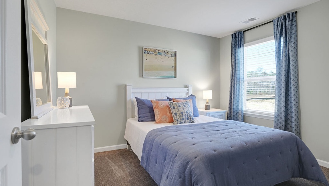 "Well-appointed secondary bedroom in the Macon floor plan with modern finishes and a welcoming atmosphere."