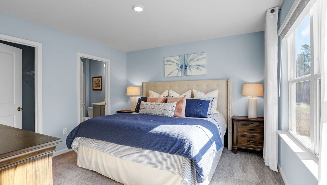 Primary bedroom with a bed and side table