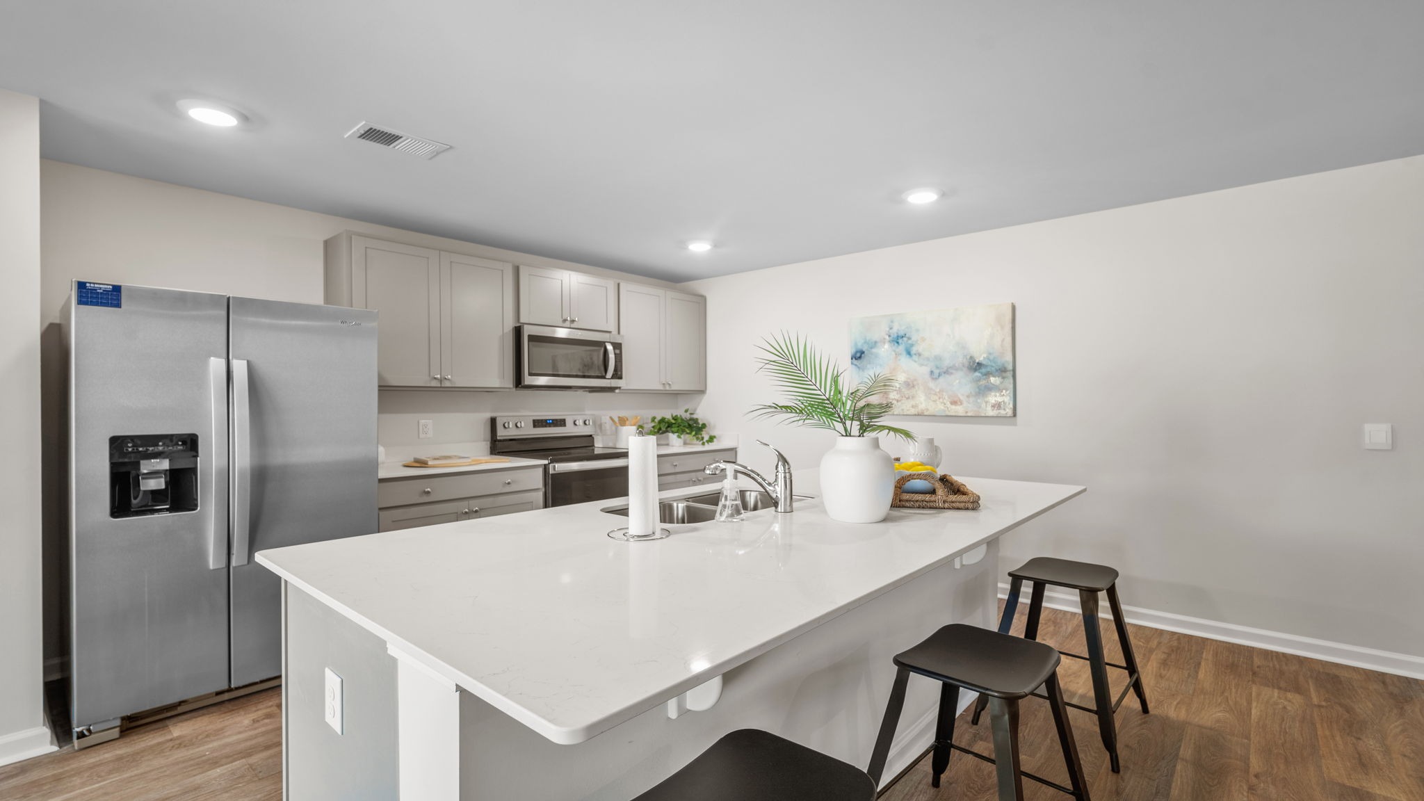 Bright and modern kitchen with stainless steel appliances, ample storage, and island seating in the popular Kerry floor plan.