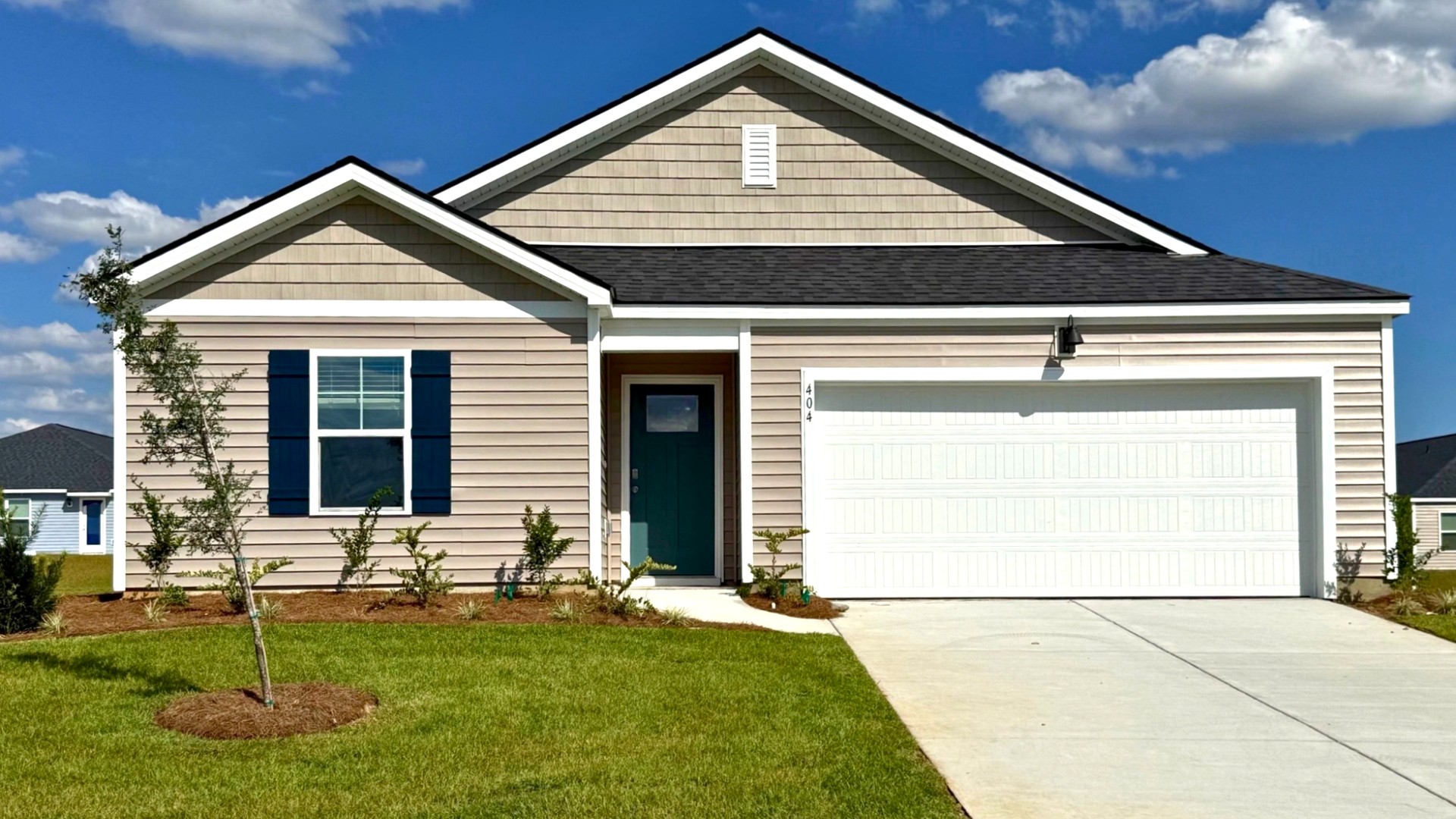 Beautiful Kerry floor plan home featuring attractive curb appeal, manicured landscaping, an attached garage, and a welcoming front entrance.