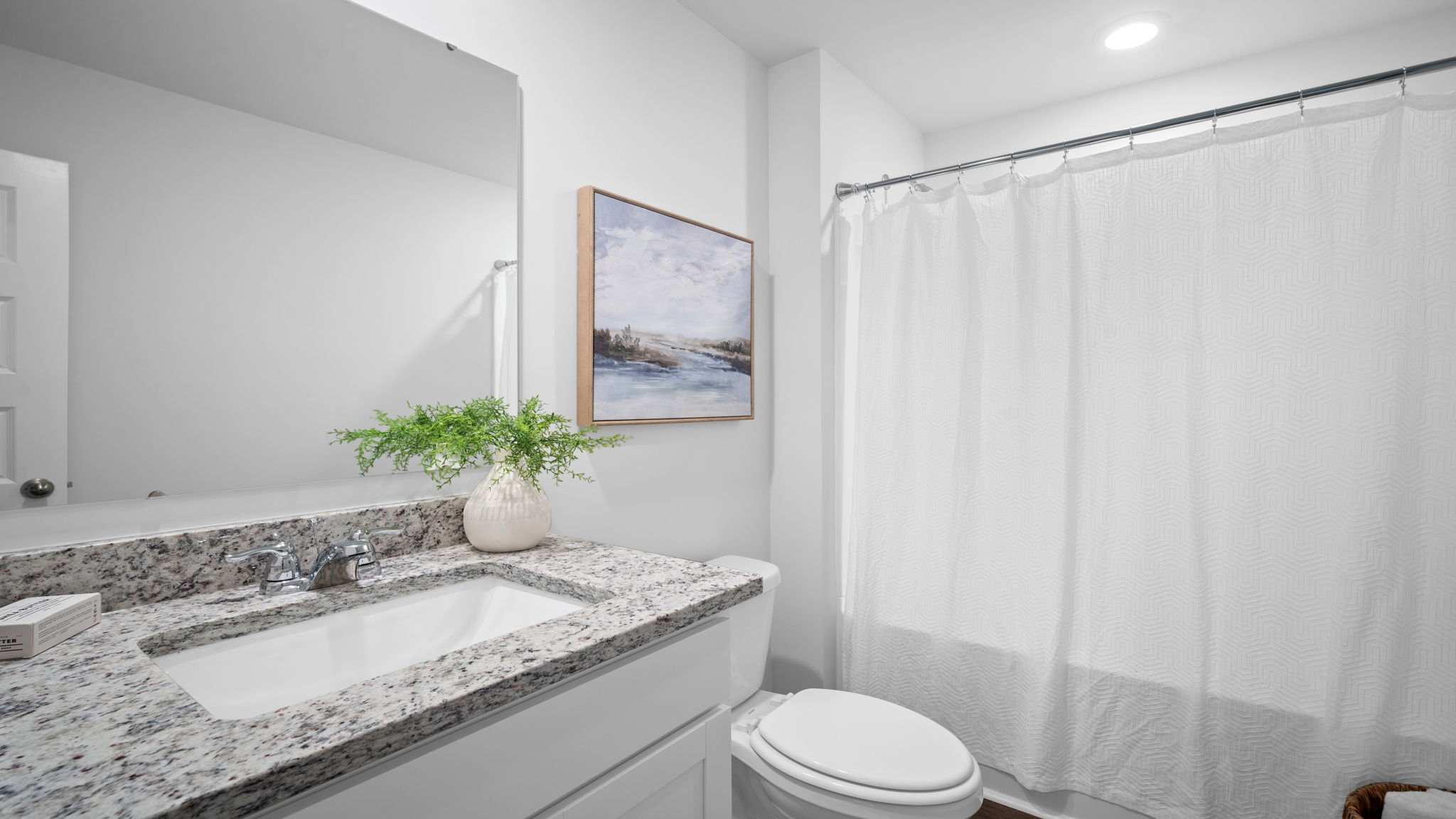 Full secondary bathroom in the Freeport floorplan featuring modern fixtures, stylish vanity, and functional family-friendly design.