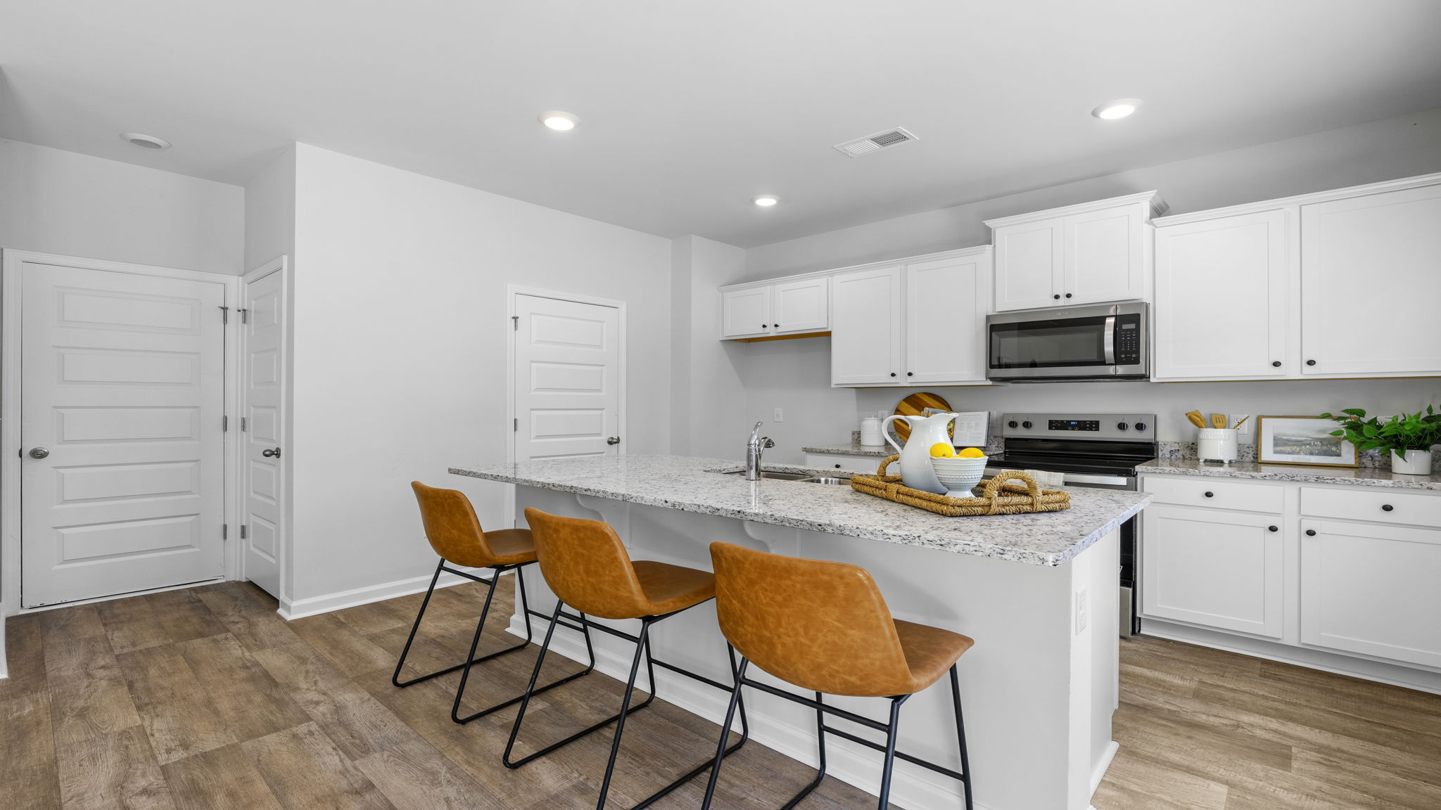 Open-concept kitchen in the Belhaven home at Holly Oaks featuring contemporary finishes, generous counter space, stainless steel appliances, and a functional layout designed for everyday living and entertaining.