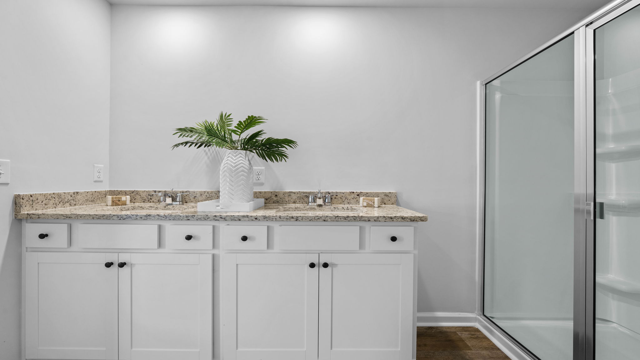 Spa-inspired owner's bath in the Belhaven home at Holly Oaks showcasing elegant finishes, bright lighting, and a functional layout with dual-sink vanity space.