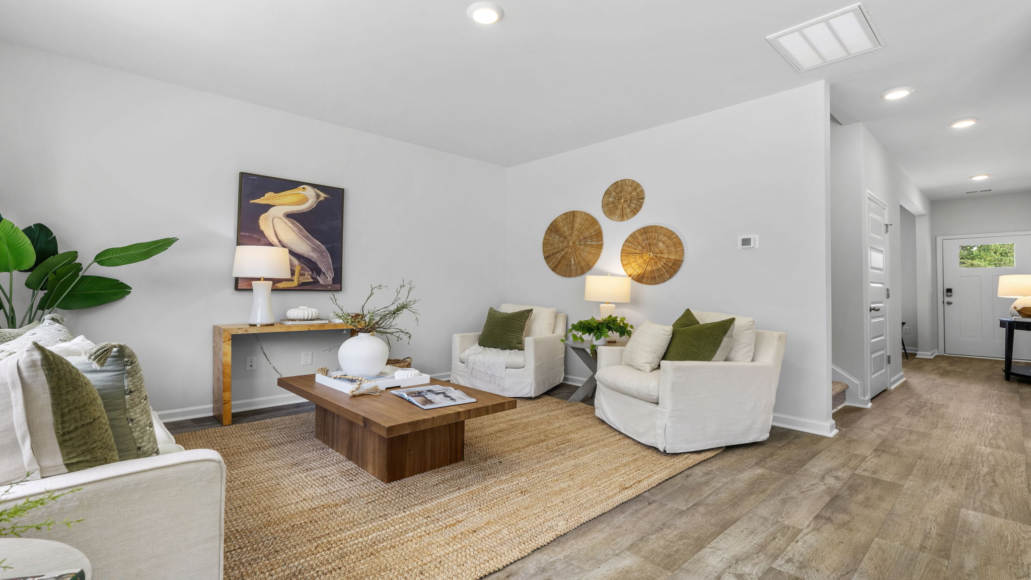 Inviting family room in the Belhaven by D.R. Horton showcasing large windows, comfortable gathering space, and seamless connection to the kitchen and dining area.