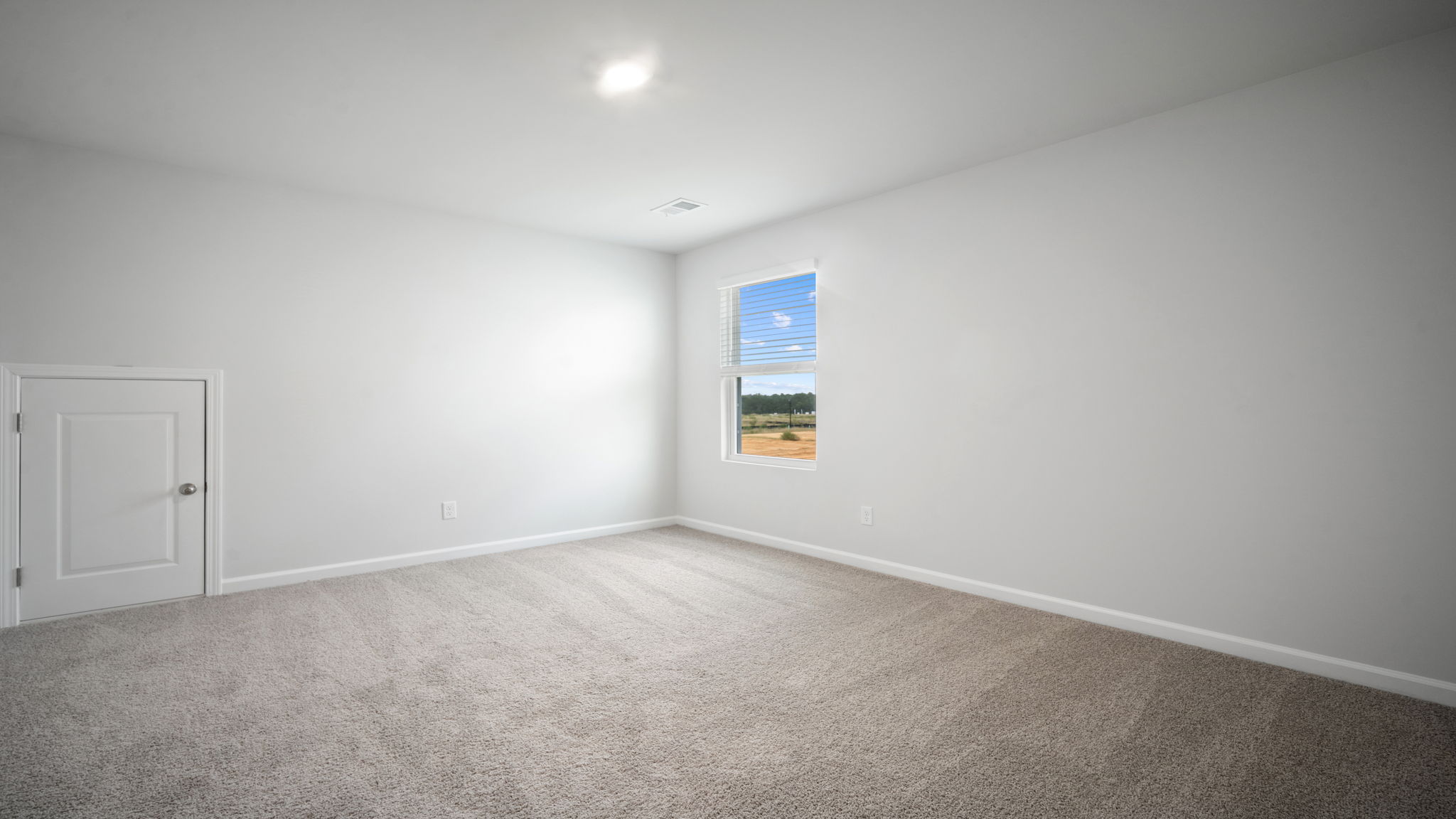 Bedroom with carpeted floors and large single window for natural light.