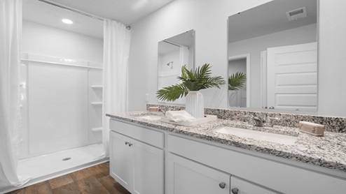 Primary bathroom with a double vanity and a stand-up shower