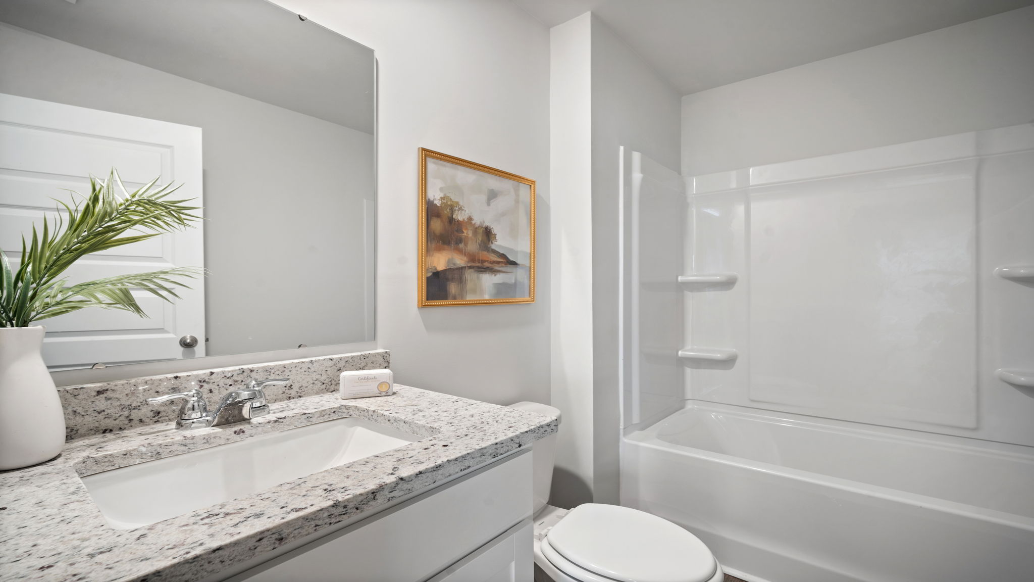 Bathroom with single sink vanity, with shower and tub combination and built in shelving.