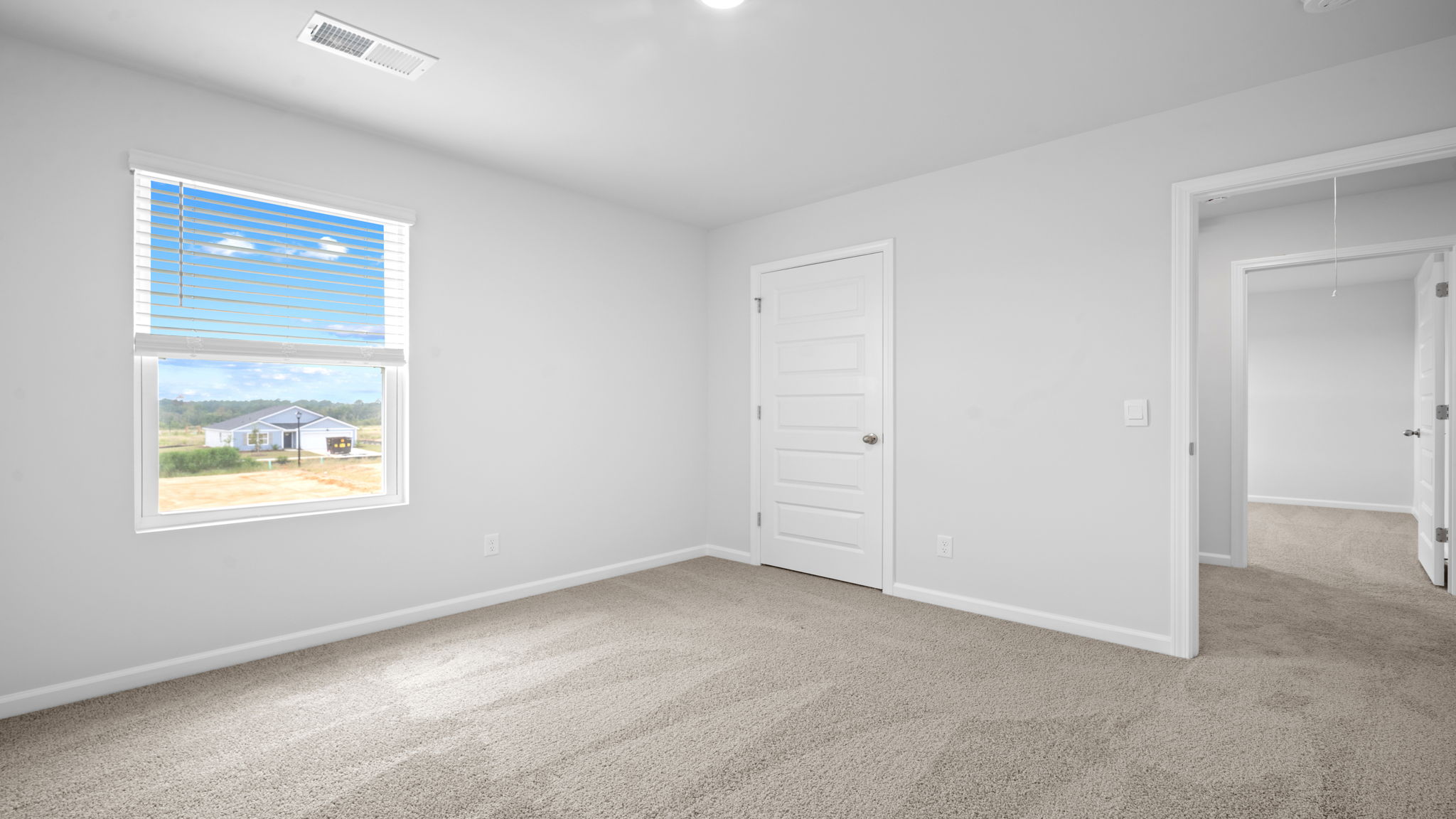 Bedroom with carpeted floors and large single window for natural light.