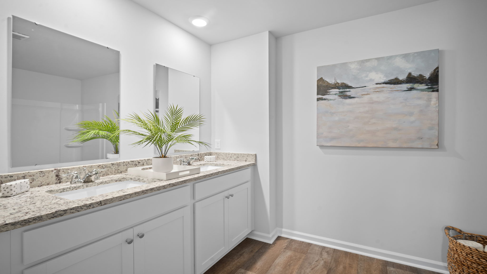 Primary bathroom with tile walk in shower, bright light fixtures, and with built in shelves. connecting walk-in closet.