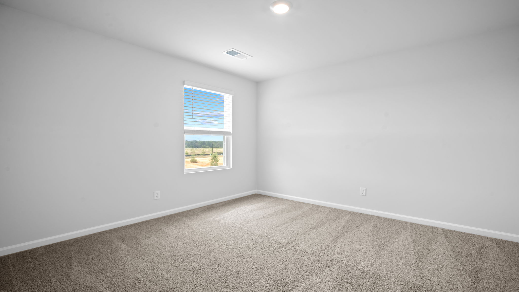 Bedroom with carpeted floors and large single window for natural light.