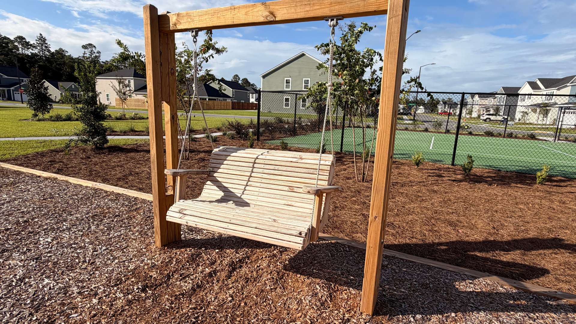 Swing seating area overlooking Laurel Grove recreational amenities.