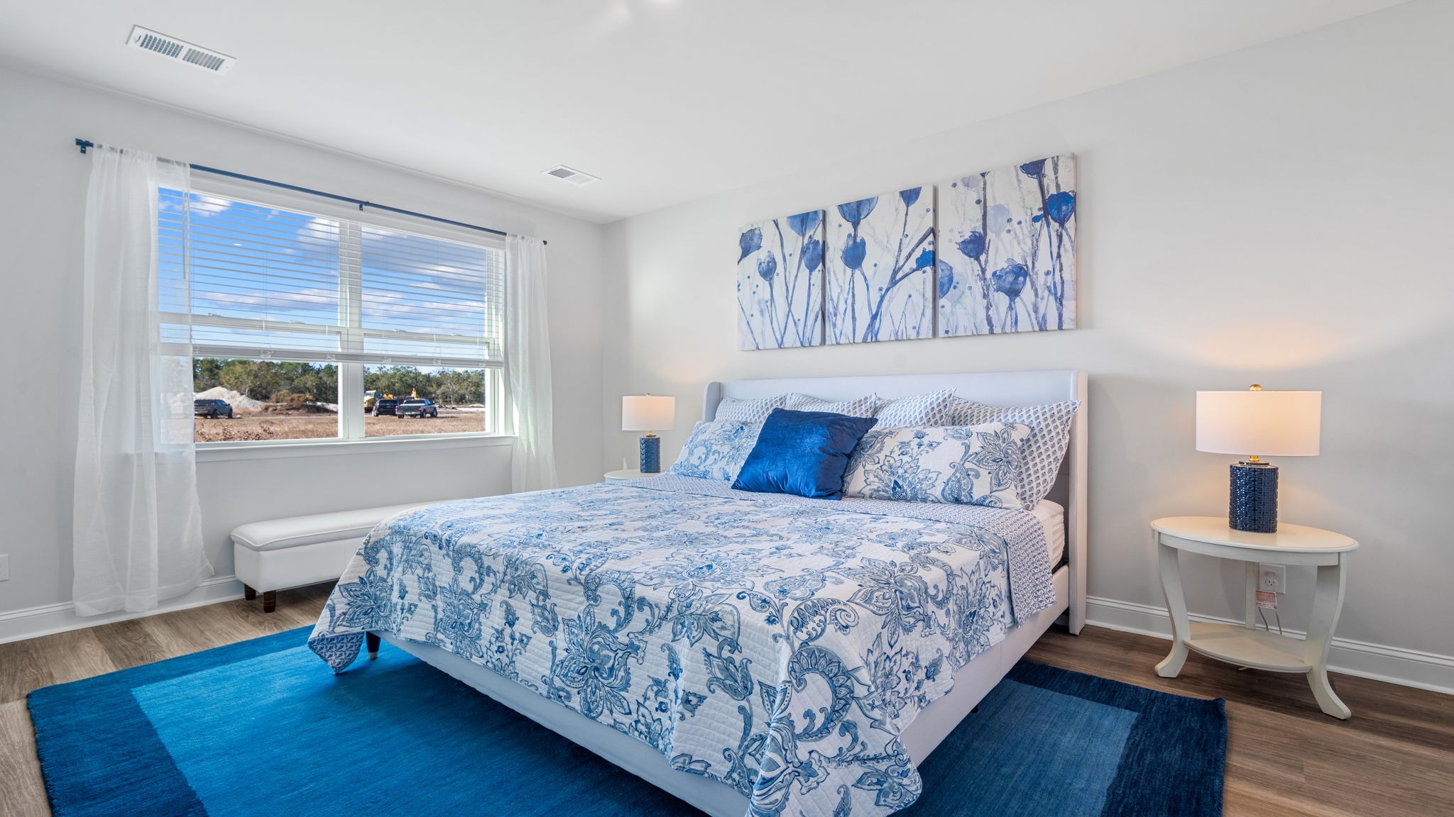 Primary bedroom decorated with a bed, side table and a dresser