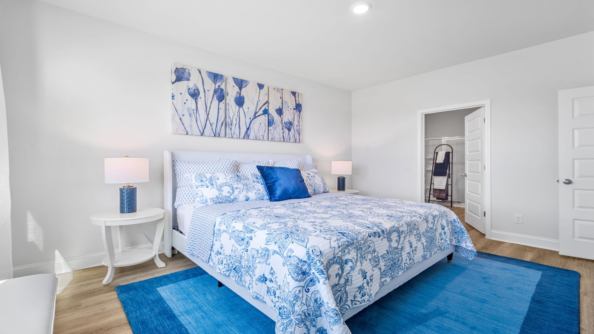 Primary bedroom decorated with a bed, side table and a dresser