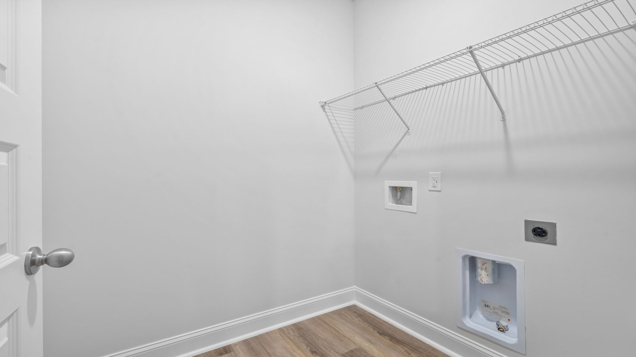 Spacious laundry area has room for a washer and dryer with built in shelves.