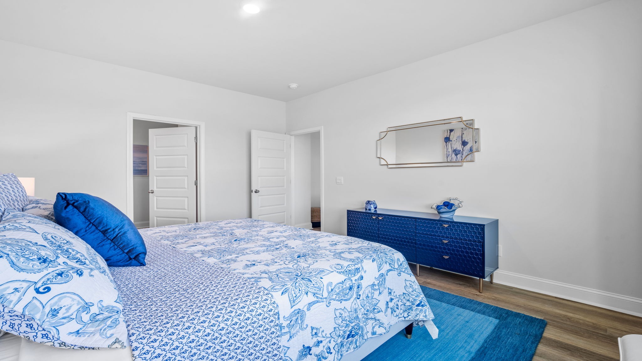 Primary bedroom with bed and dresser