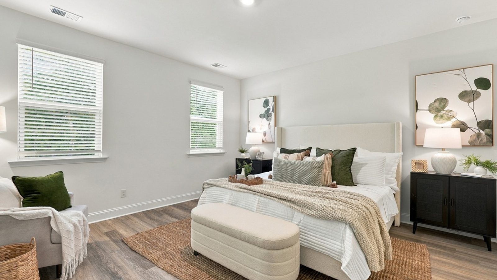 Spacious primary bedroom featuring large windows, natural light, and room for a full bedroom suite.