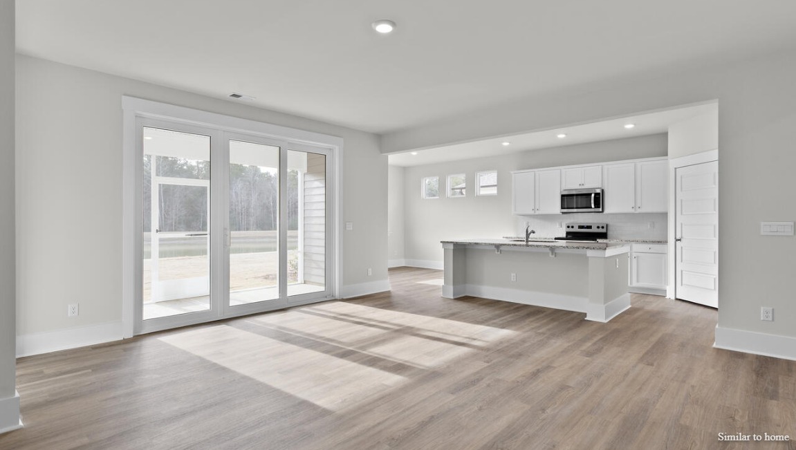 Modern kitchen in the Martin by D.R. Horton featuring spacious countertops, ample cabinetry, and open sightlines.