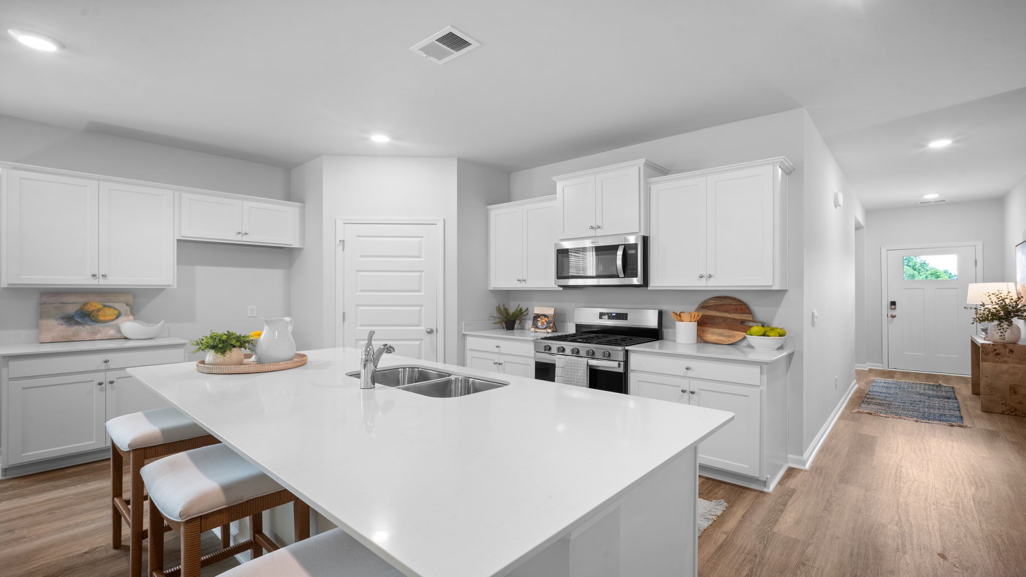 Open-concept kitchen in Lakeside floor plan with large center island, stainless steel appliances, and seamless flow to dining and living areas