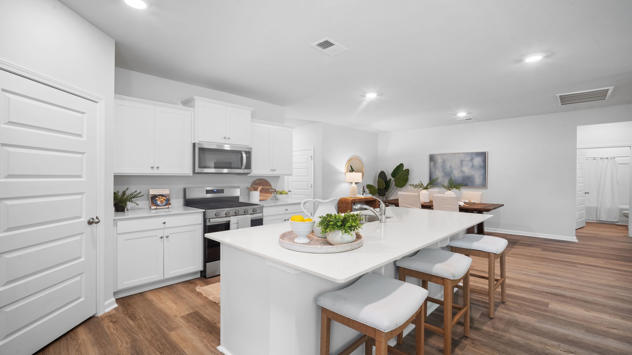 Spacious kitchen design in Lakeside model home with island seating and open view of main living space